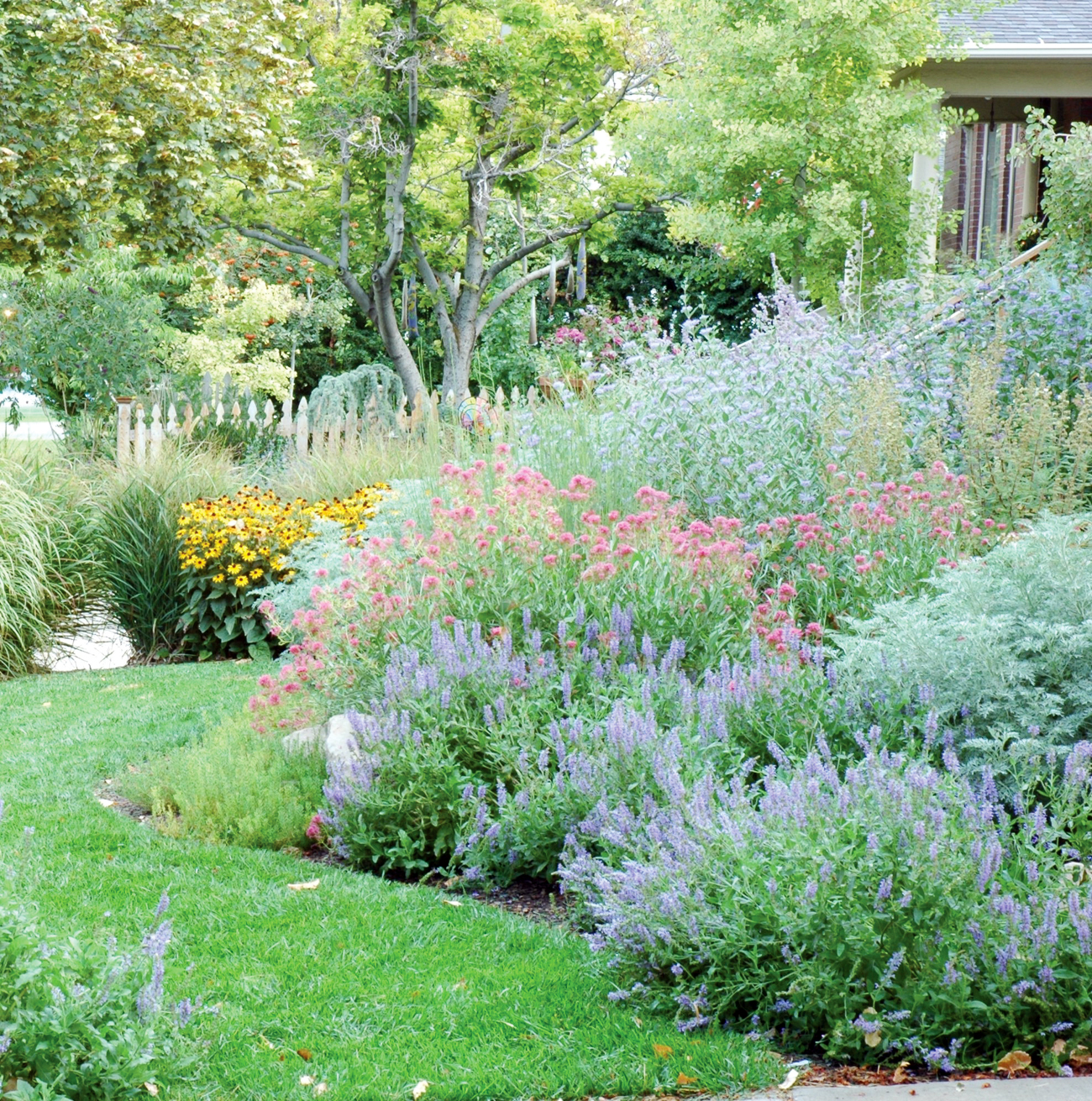 A lush lawn and a gorgeous hillside of vibrant varying colors of flowers.