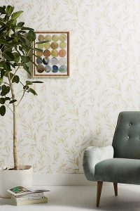 green armchair, indoor plant and stack of magazines