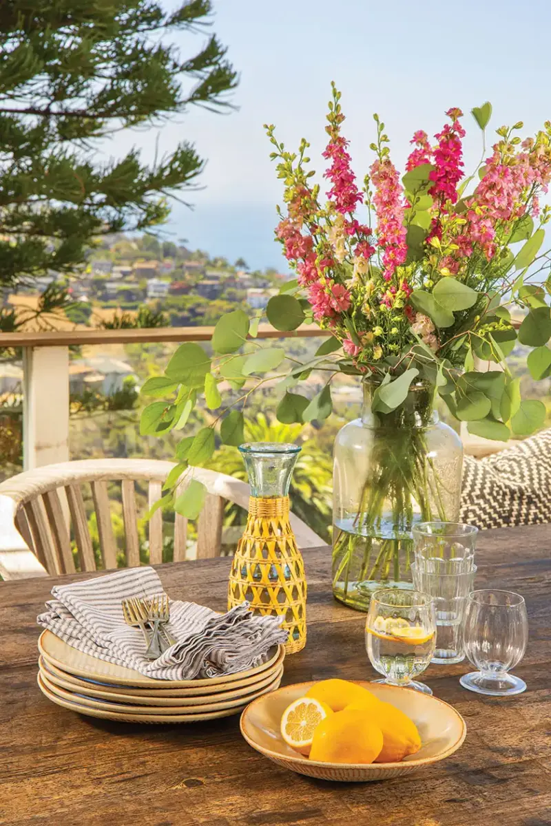 flowers and fresh lemons on patio table in 1940s beach cottage