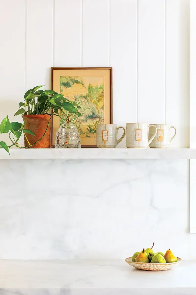 marble counter and half wall with shiplap and exposed shelf in 1940s beach cottage