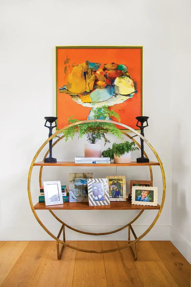 orange abstract still life with round bookshelf displaying family photos