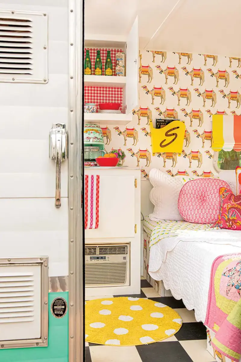 gingham background in camper kitchen shelves and bright yellow magazine holder