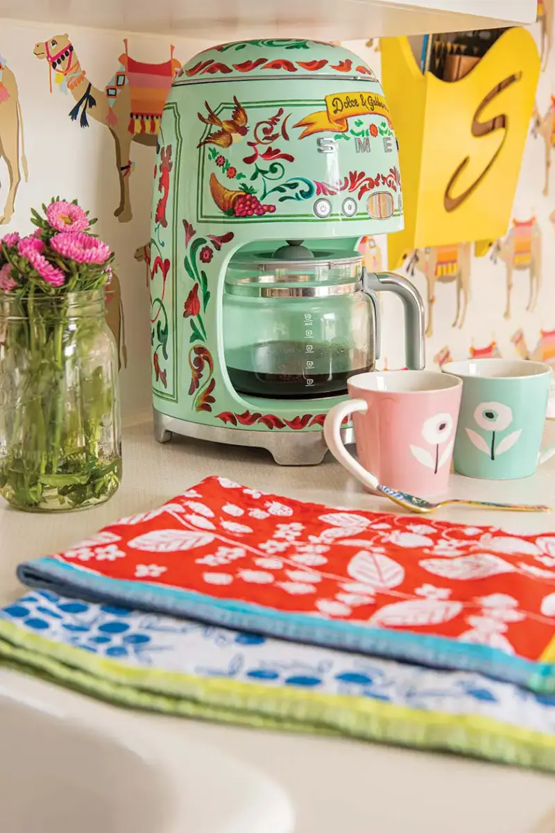 SMEG special edition coffee maker and colorful coffee mugs and tea towels in camper