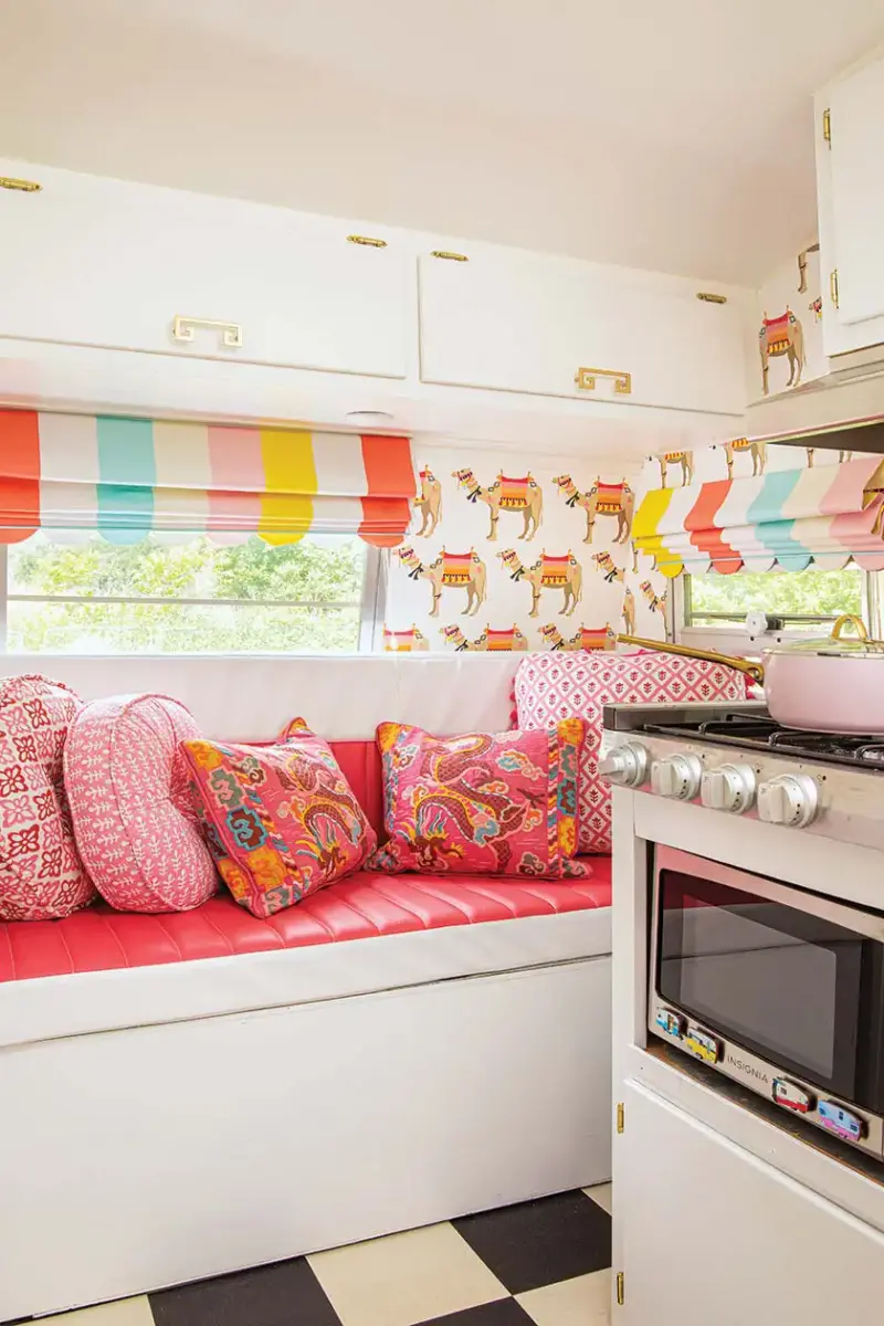 pink bench seating with colorful patterened pink pillows in colorful camper