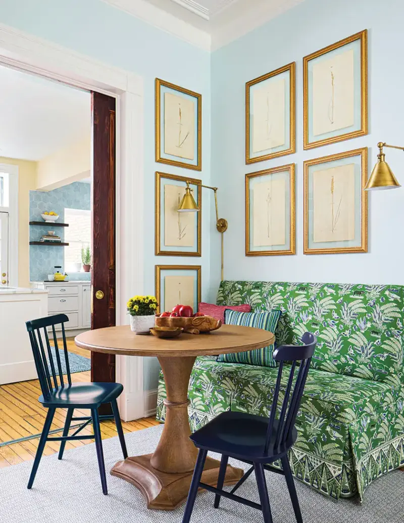 green upholstered banquette paired with circular table and black wooden chairs