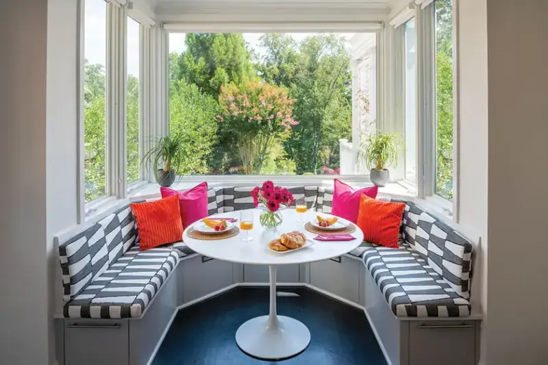 Saarinen tulip table paired with built-in three sided banquette with black and white upholstery