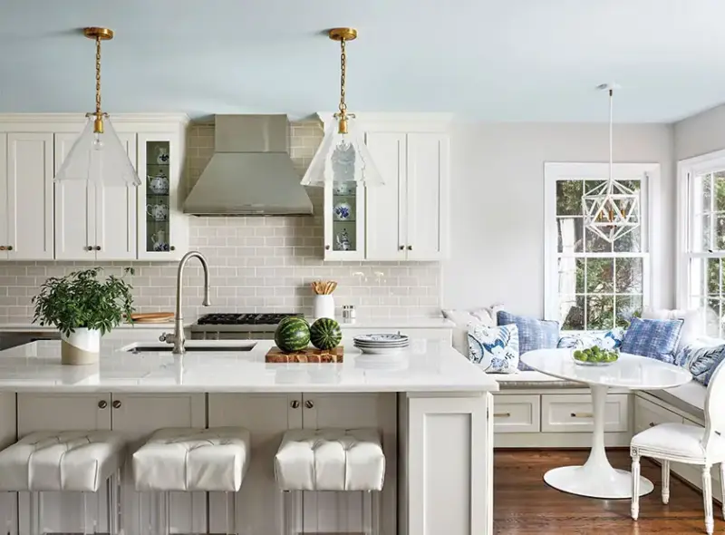 white cottage kitchen with two sided banquette and Saarinen tulip table