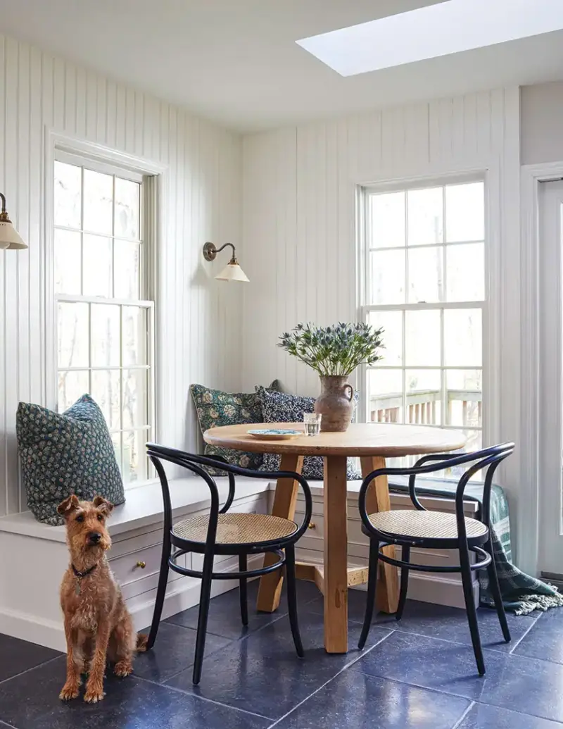 beadboard pitcher of blue thistle and dog add cozy touches to banquette dining area