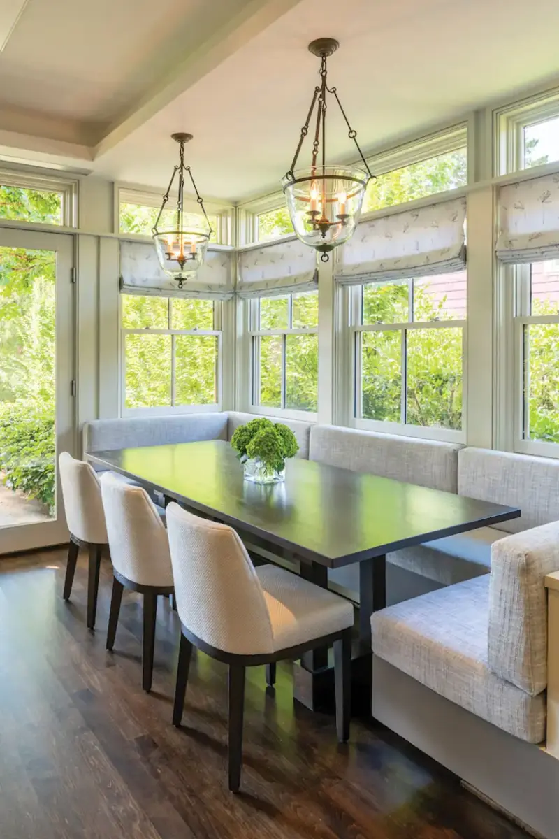 three sided neutral banquette along wall of windows