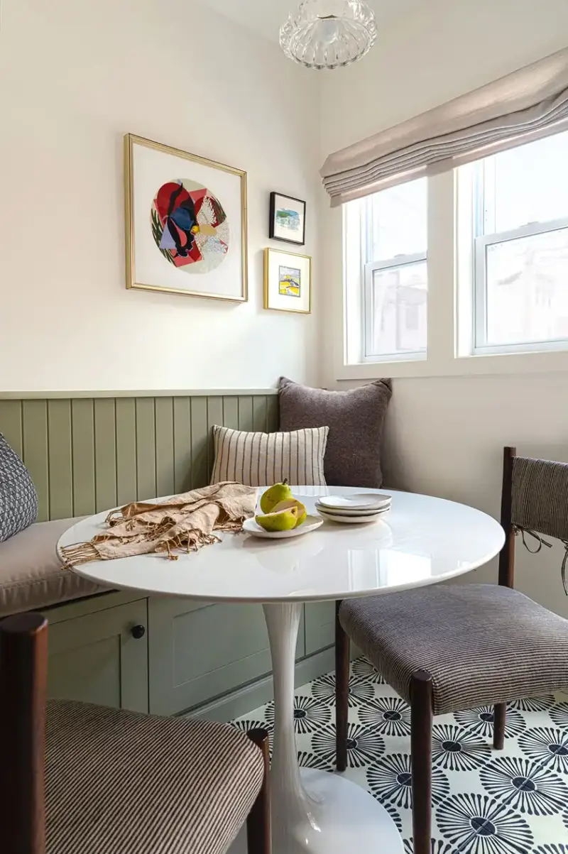 green banquette with beige cushion paired with tulip table and graphic pattern floor