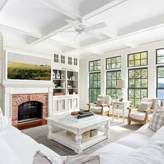 lakeside farmhouse cottage living room with lake view fireplace landscape painting and white color scheme