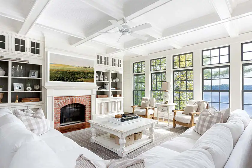 lakeside farmhouse cottage living room with lake view fireplace landscape painting and white color scheme