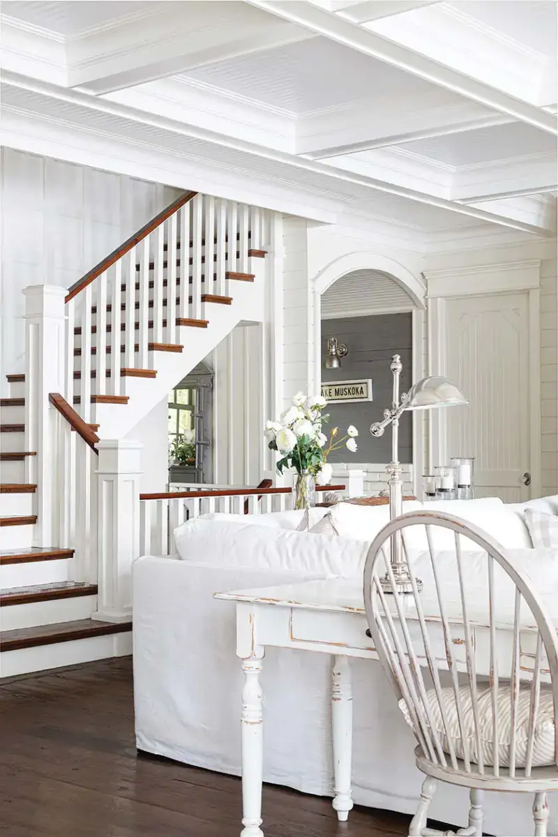 white coffered ceiling white farmhouse furniture and wood staircase in lakeside cottage farmhouse