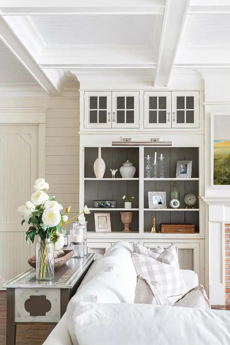 living room with built-in shelving with dark gray back and white front in lakeside cottage farmhouse