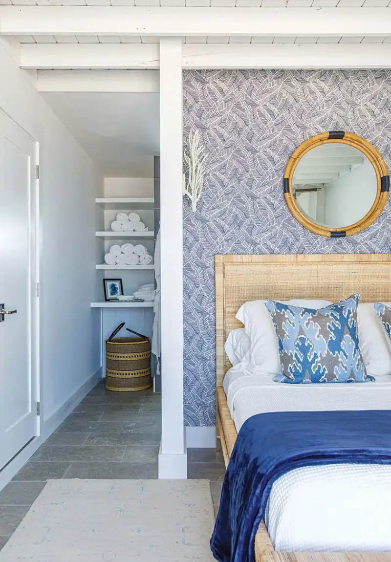 master bedroom in Florida beach bungalow with grasscloth wallpaper and cane bedframe and headboard