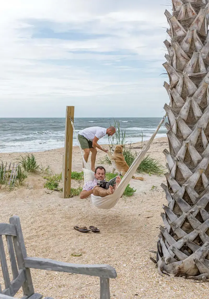 enjoying beachfront yard in a hammock and playing with dog