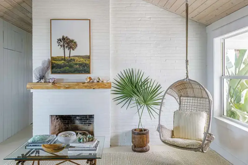 hanging chair, fireplace and jute rug in coastal living room