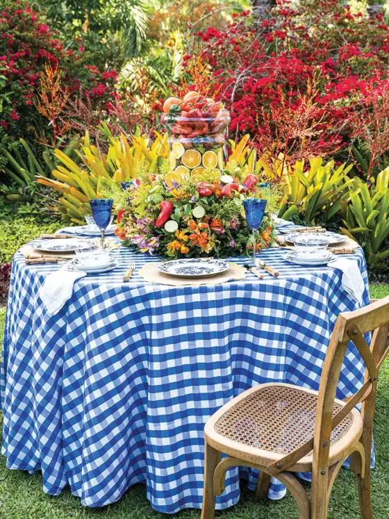 al fresco tablescape with blue and white gingham cloth and overflowing edible centerpiece