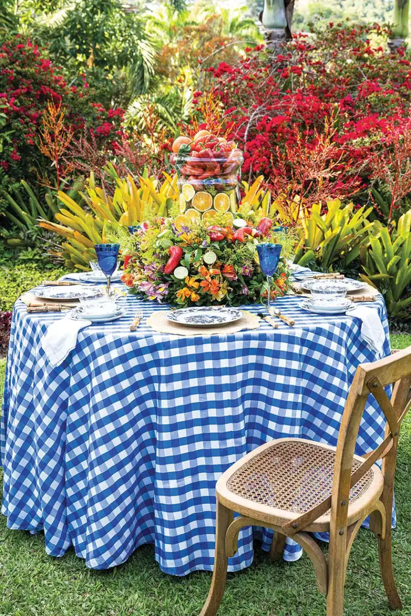 al fresco tablescape with blue and white gingham cloth and overflowing edible centerpiece