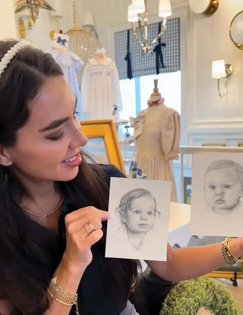 Cara Fox holding two drawings of babies