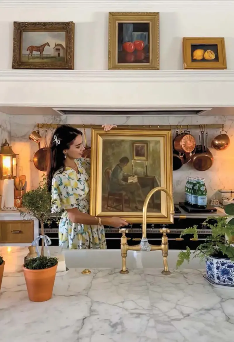 Cara Fox holding painting of woman reading by candlelight