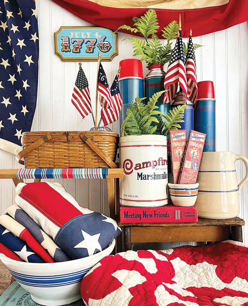 Fourth of July vignette with vintage thermoses small flags and white and blue kitchenalia