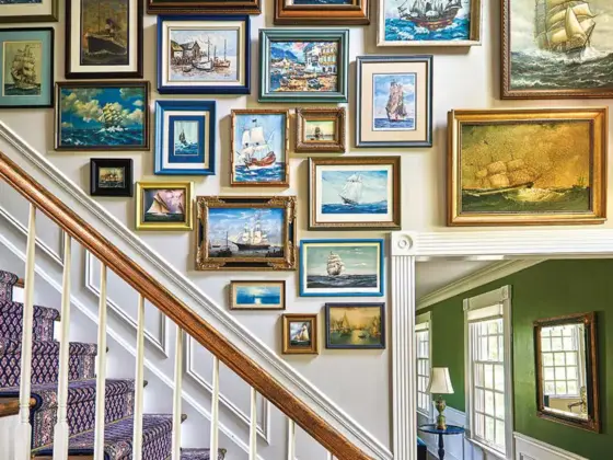 gallery wall of nautical art along staircase