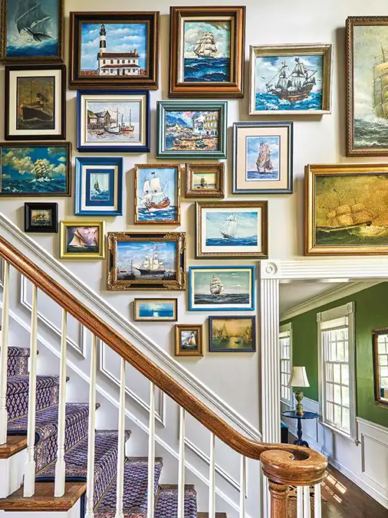 gallery wall of nautical art along staircase