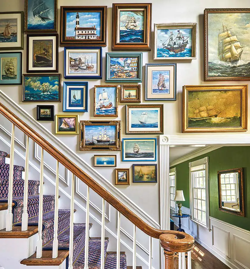 gallery wall of nautical art along staircase