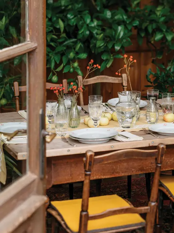 red apples serve as the centerpiece at this table set for outdoor fall feasting