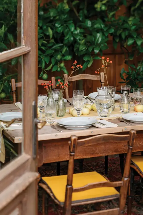 red apples serve as the centerpiece at this table set for outdoor fall feasting