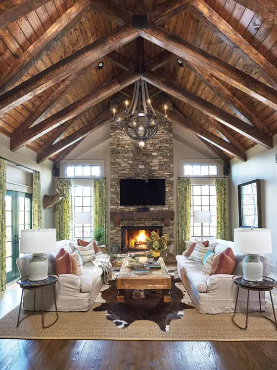 living room with rounded metal chandelier layered rugs and warm fire in rustic Craftsman cottage with modern touches