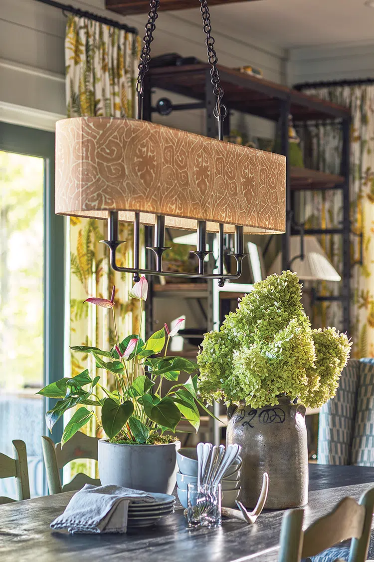 long shaded chandelier above dining table in rustic Craftsman cottage with modern touches