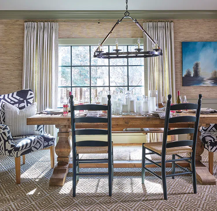 grasscloth wallpaper and upholstered dining chairs on either end of dining table in Craftsman cottage