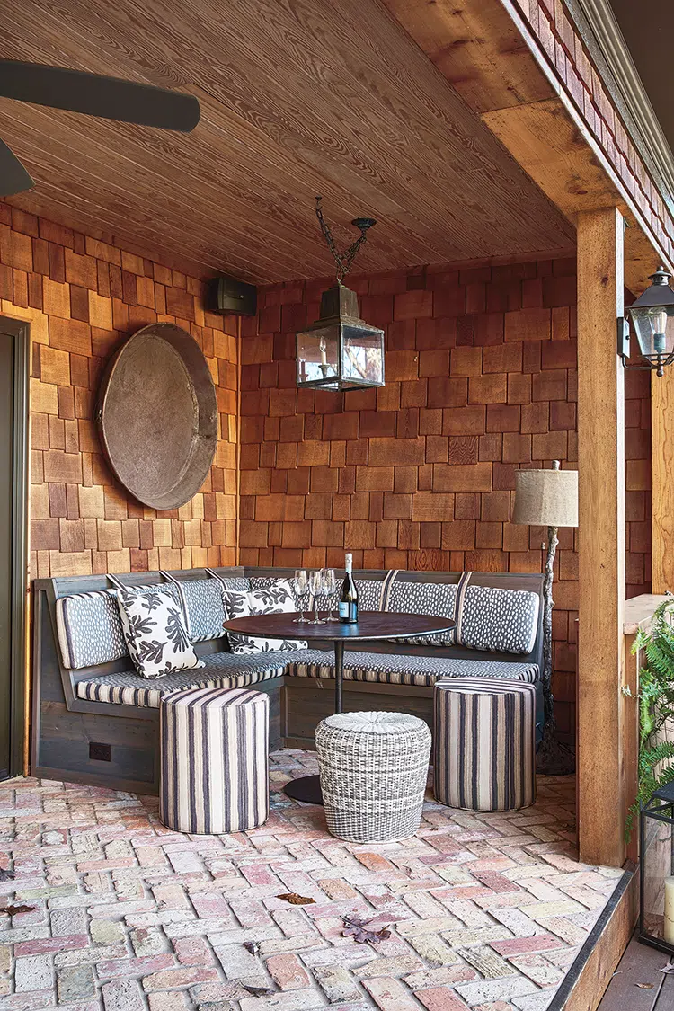 outdoor banquette in covered porch with herringbone brick floor