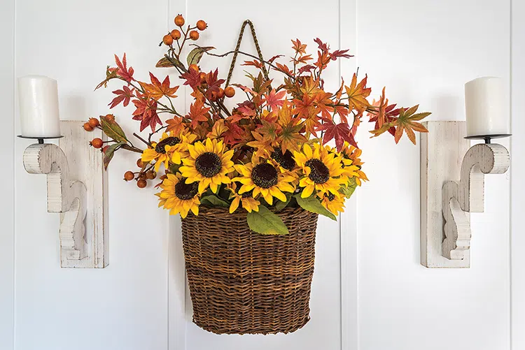 faux floral bouquet in woven basket serves as fall wall decor in white cottage