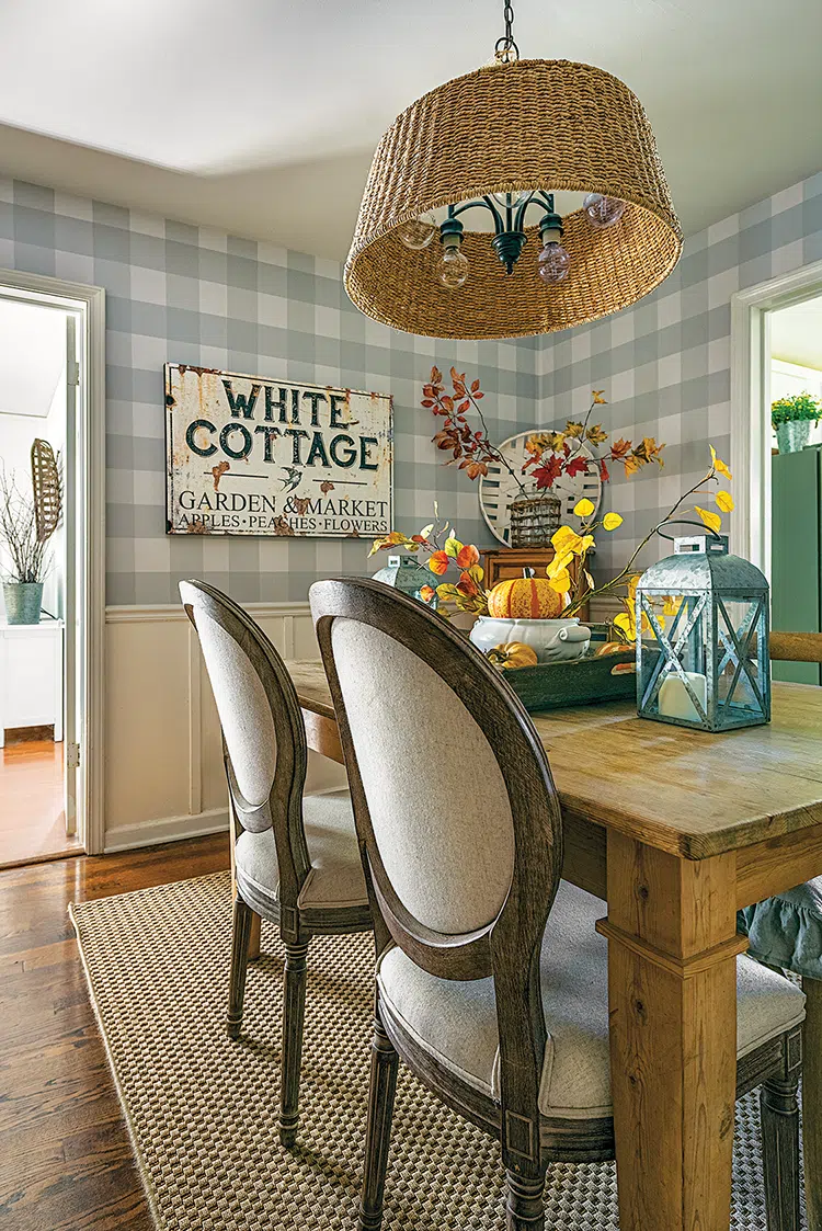 dining table in cozy cottage fall mode with removable centerpiece with faux fall branches and decorative pumpkins