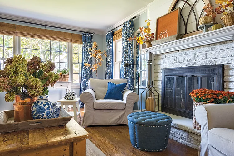 cozy cottage fall living room with basket of mums and faux fall branches