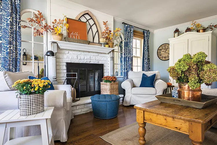 blue and white cottage living room decorated for fall with faux branches and rust orange hello fall word art