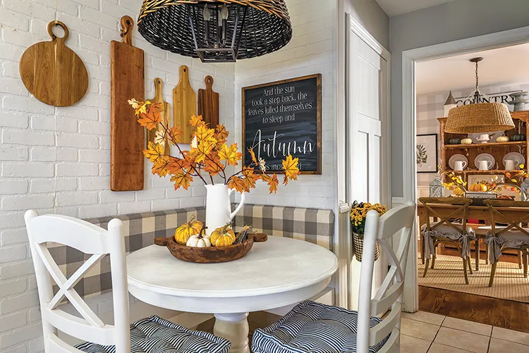 breakfast nook with decorative pumpkins and fall branches as centerpiece