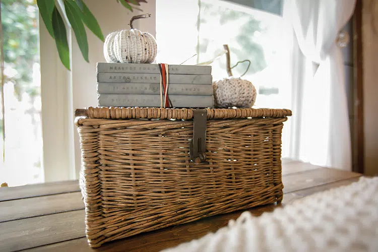 fall vignette with woven basket and crocheted white pumpkins