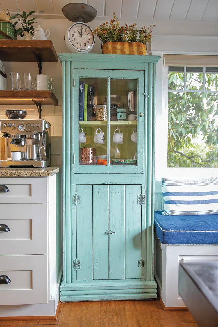 turquoise hutch with cookbooks and hanging coffee mugs