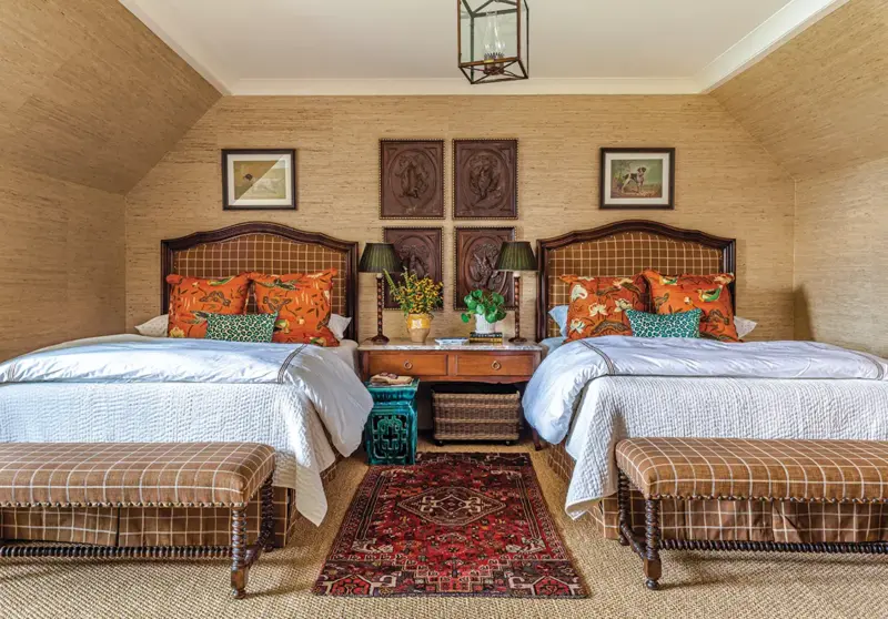 guest room with beige grasscloth wallpaper and brown upholstery on two beds