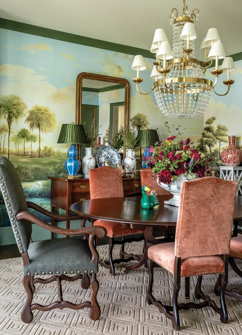 landscape wallpaper in Georgia home dining room with collected antique lamps and vases