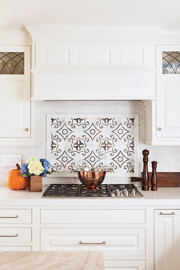 traditional tile backsplash and white kitchen cabinets in renovated La Jolla kitchen