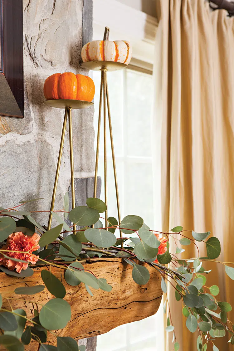 pumpkins elevated on brass candle stands