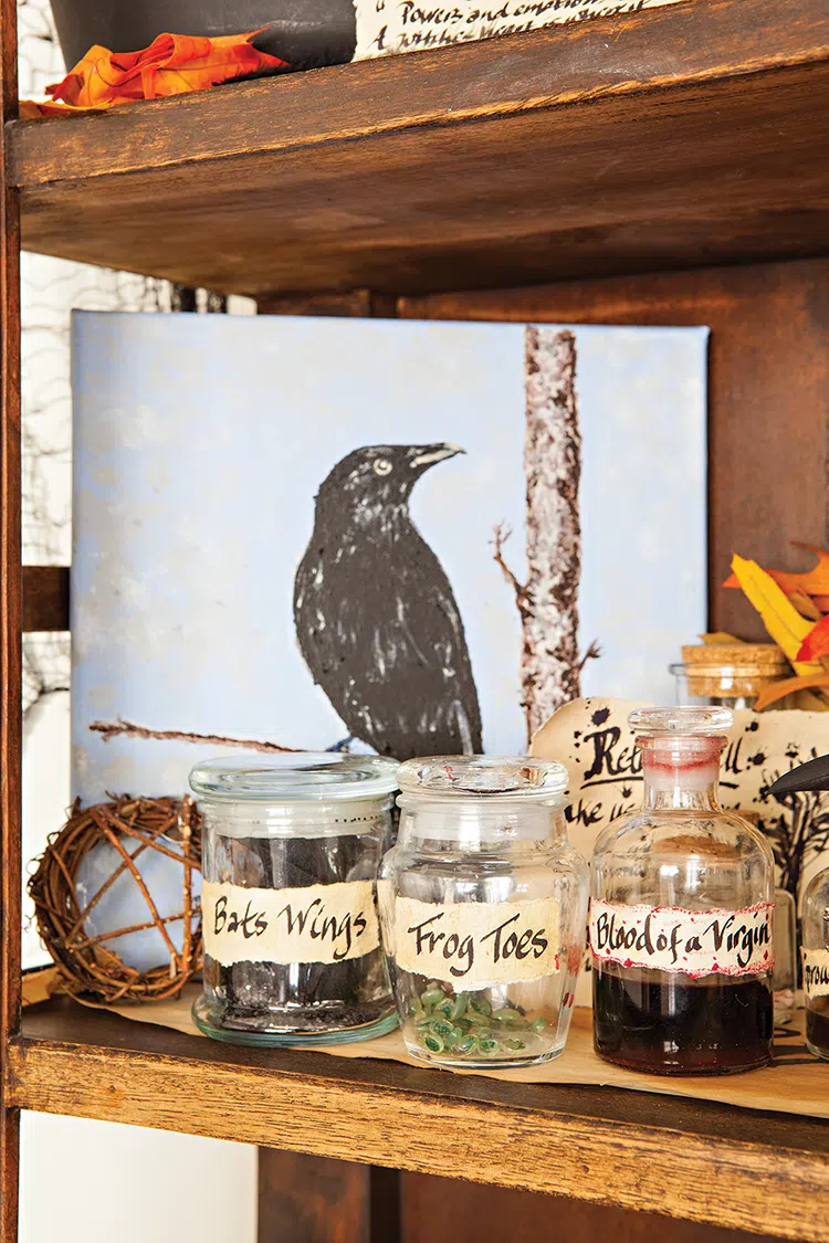 spooky and sophisticated Halloween with hand labelled jars on shelf along with painting of crow