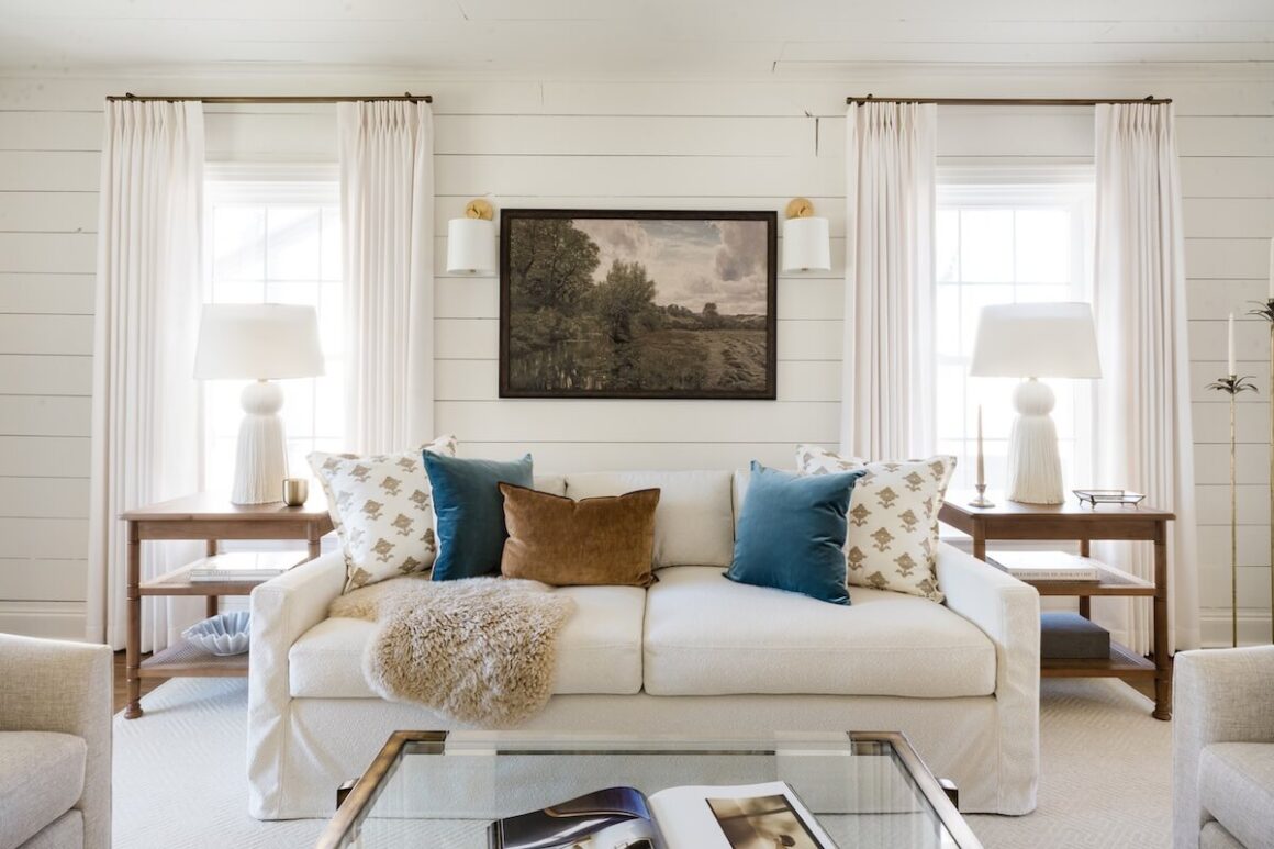 living room with neutral color scheme, shiplap walls and landscape painting