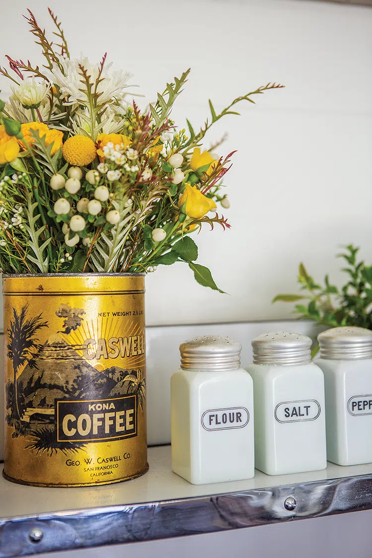 vintage coffee tin with yellow flowers on a shelf with vintage flour, salt and pepper shakers