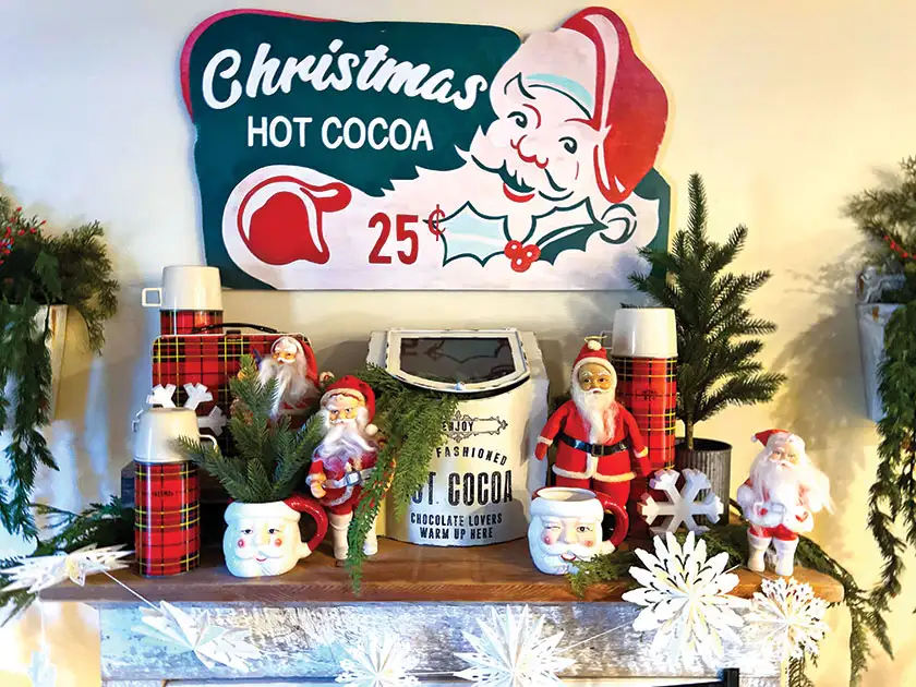 hot cocoa bar with vintage Santa figurines and vintage thermos collection